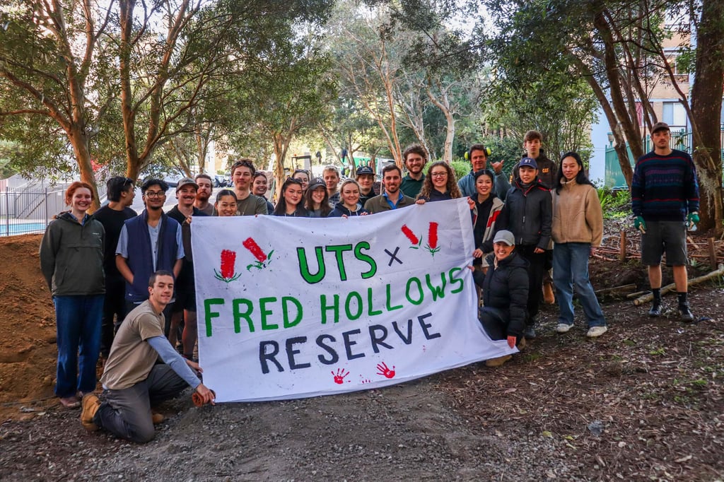 Tanya Wood and University of Technology Sydney students holding a banner at Fred Hollows Reserve.