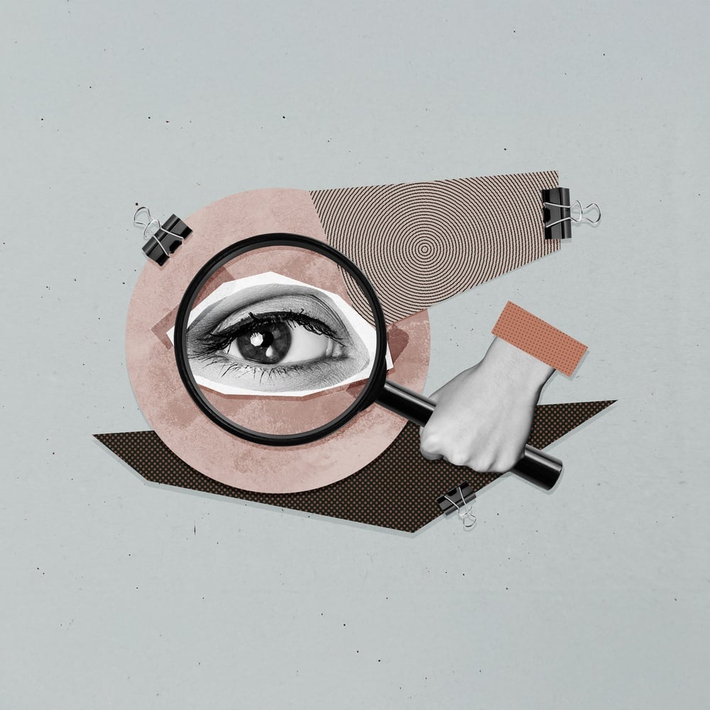 A collage of an eye covered by a magnifying glass over strips of paper