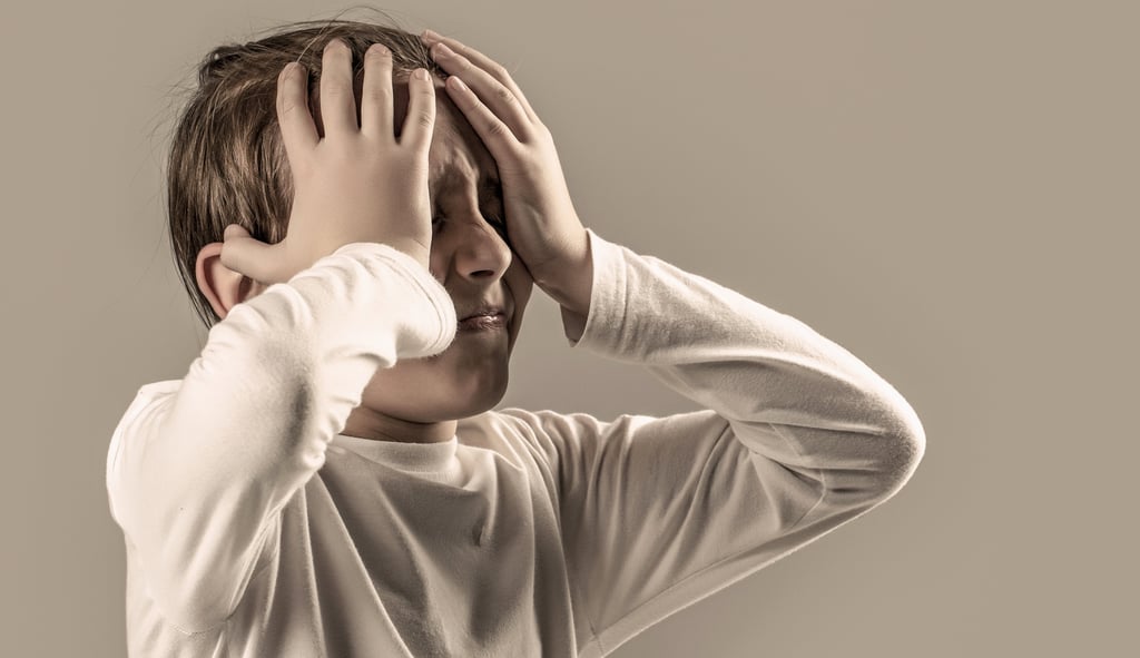 Stock picture of a child in pain holding his head in his hands.
Picture by Yevhen/Adobe Stock