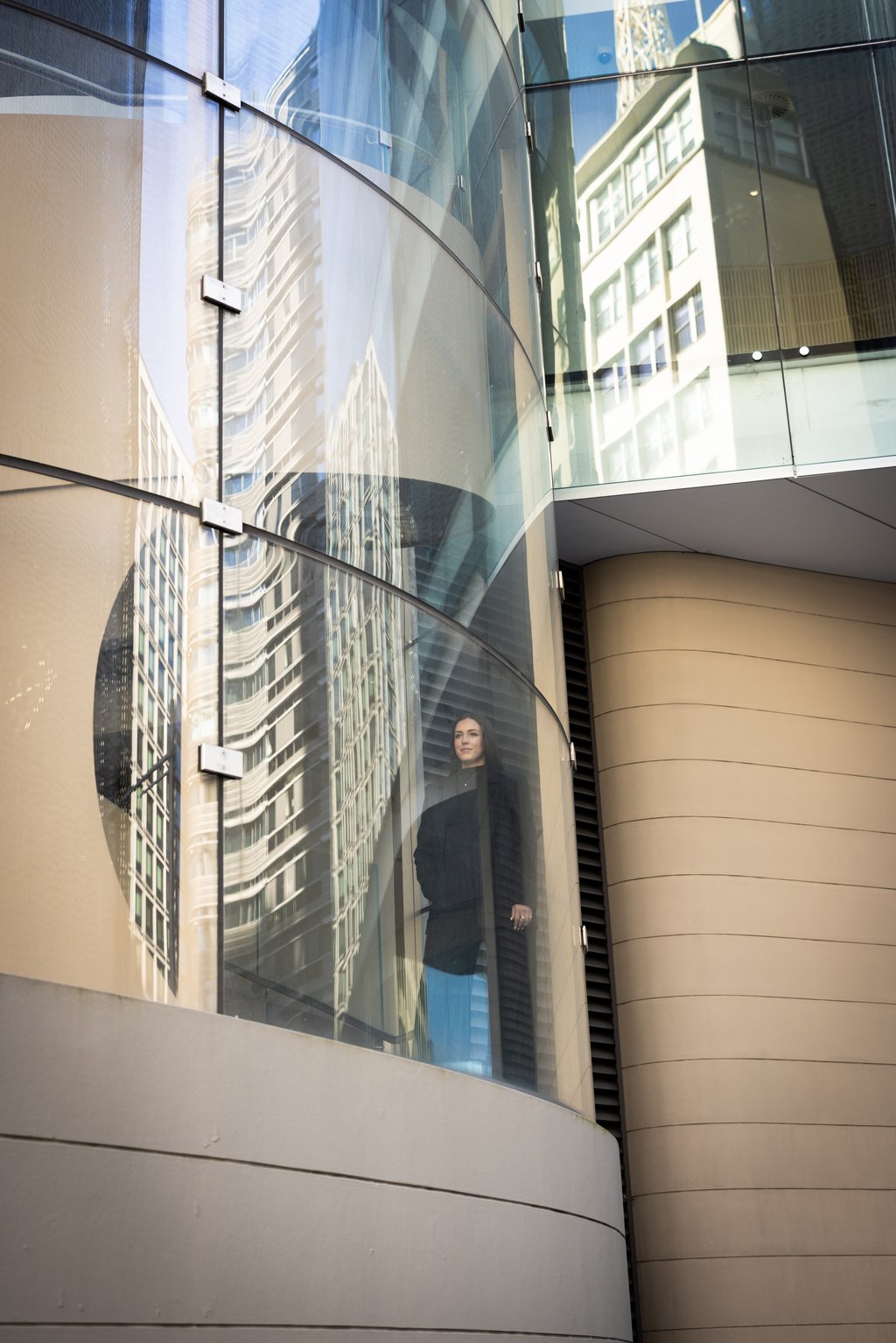 A distant shot of Georgia looking through a curved glass window