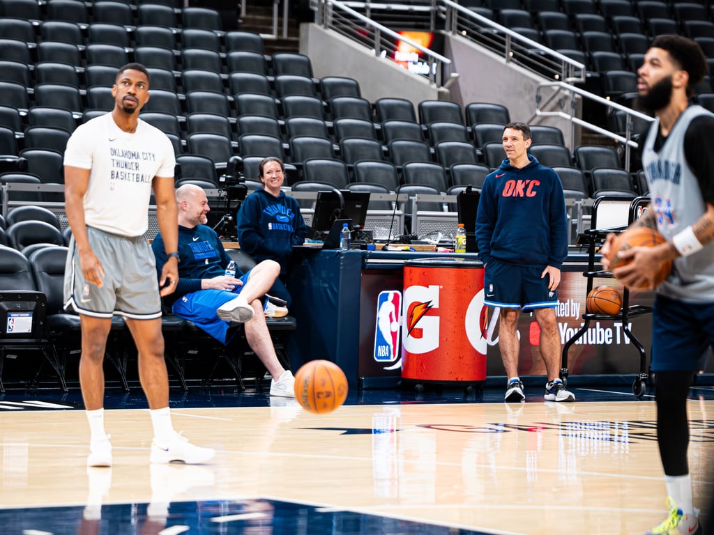Players and coaching staff from the Oklahoma City Thunder basketball team practice on court.