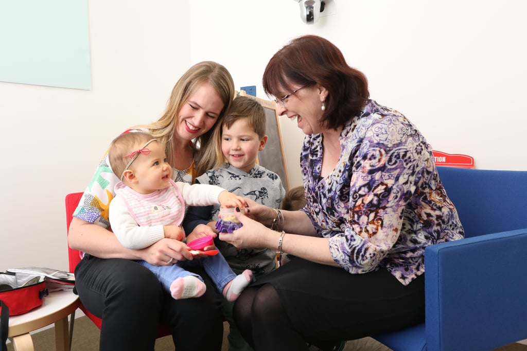 A Speech Pathologist with a mother and her two children.