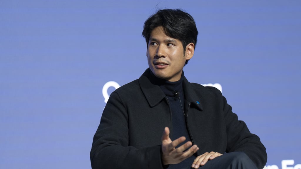 Alex Cheng sitting on the stage at the 2025 World Economic Forum held in Davos as guest panelist