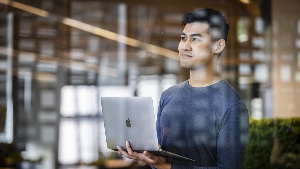 University of Technology Sydney student holding an Apple MacBook
