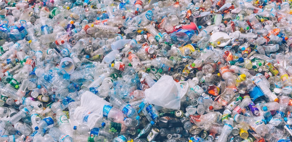 A vast pile of discarded plastic bottles and containers fills the frame.