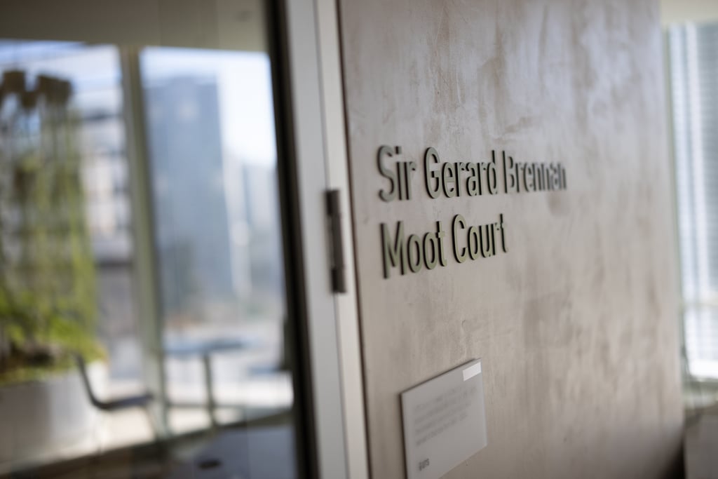The entry door to the moot court, with the sign "Sir Gerard Brennan Moot Court" printed on the wall in raised font