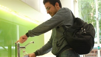 Student filling water bottle Blg 5 student lounge
