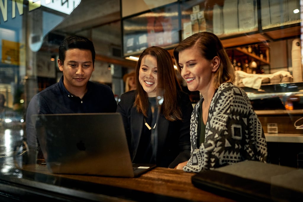 3 students working at a laptop