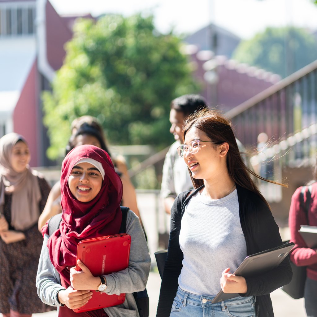 Young multicultural students walking and talking