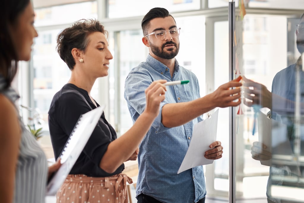 Professional staff collaborating at a whiteboard