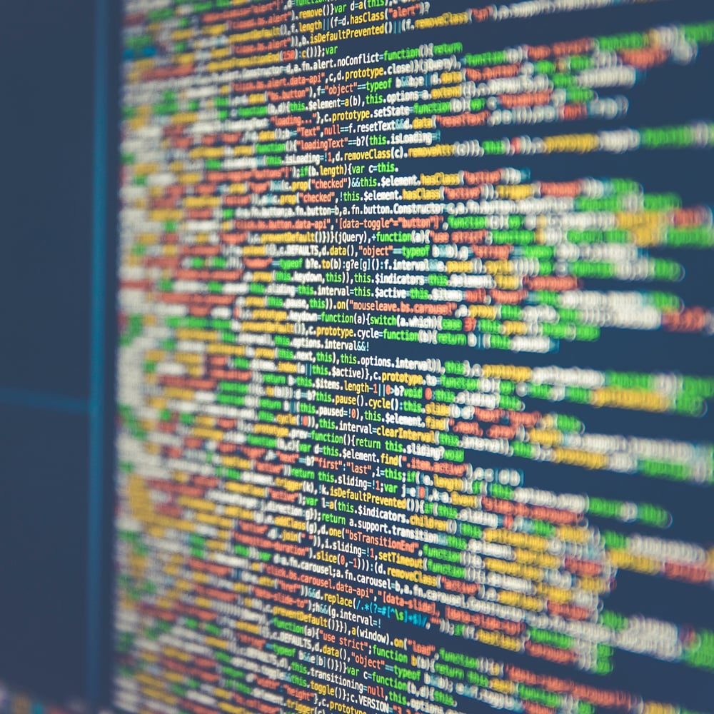 Two computer screens display programming code