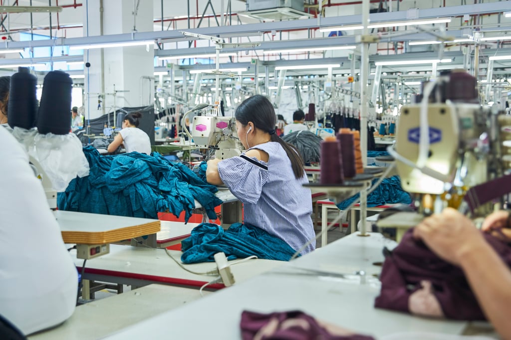 Employees working with their sewing machines in clothing factory. Picture by Lnunes?Adobe Stock