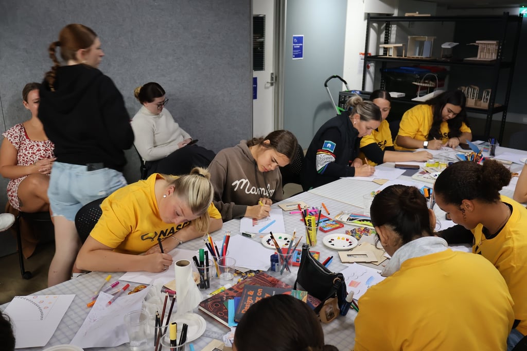 Indigenous high school students working on designs at the NASCA workshop