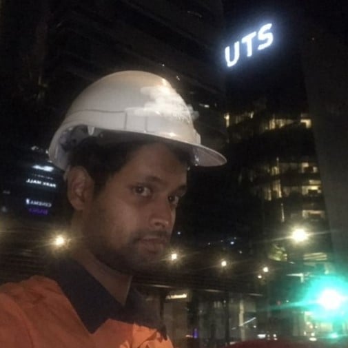 Kiri Yogarajah in a hard hat outside the UTS campus at night