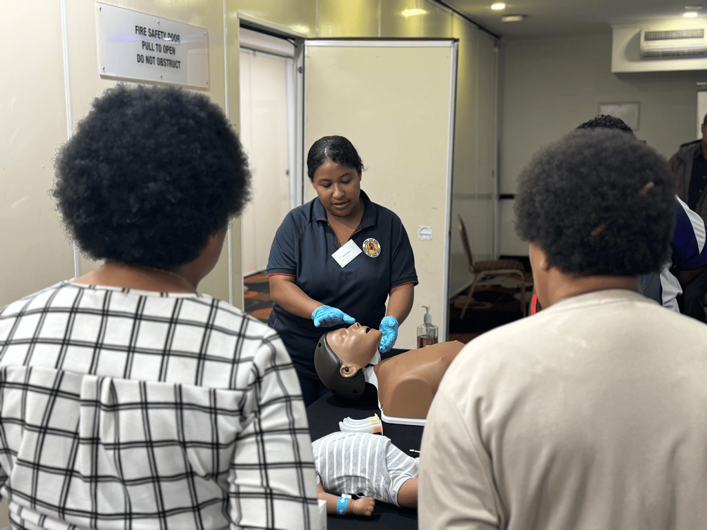Sr Marcia Willie (centre) demonstrates a procedure on a training mannequin.