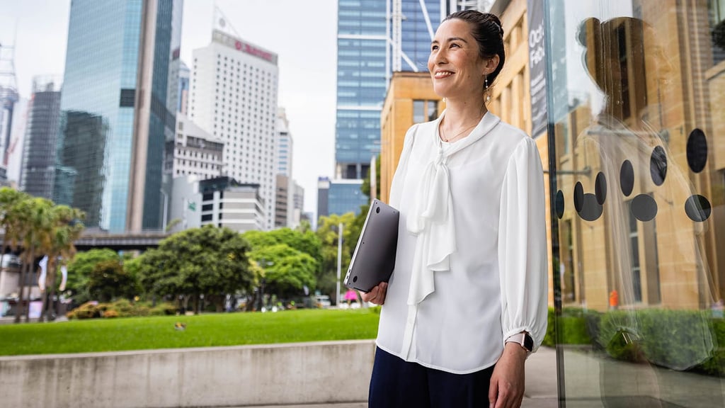 Woman walking around university campus with buildings in background