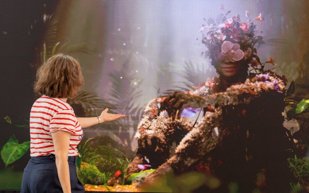 A woman interacting with ReBloom, an immersive art installation nurturing emotional resilience in young women.