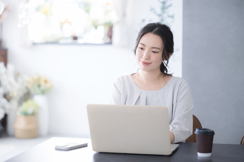 Young woman looking at a laptop in an office.