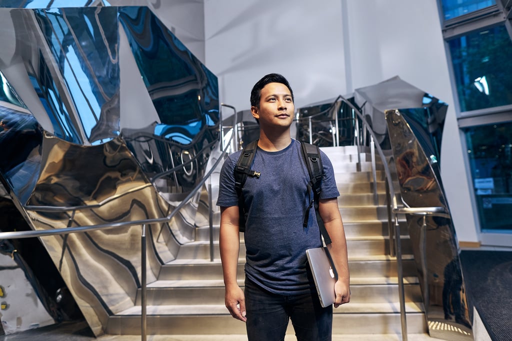 A student in front of the building 8 staircase