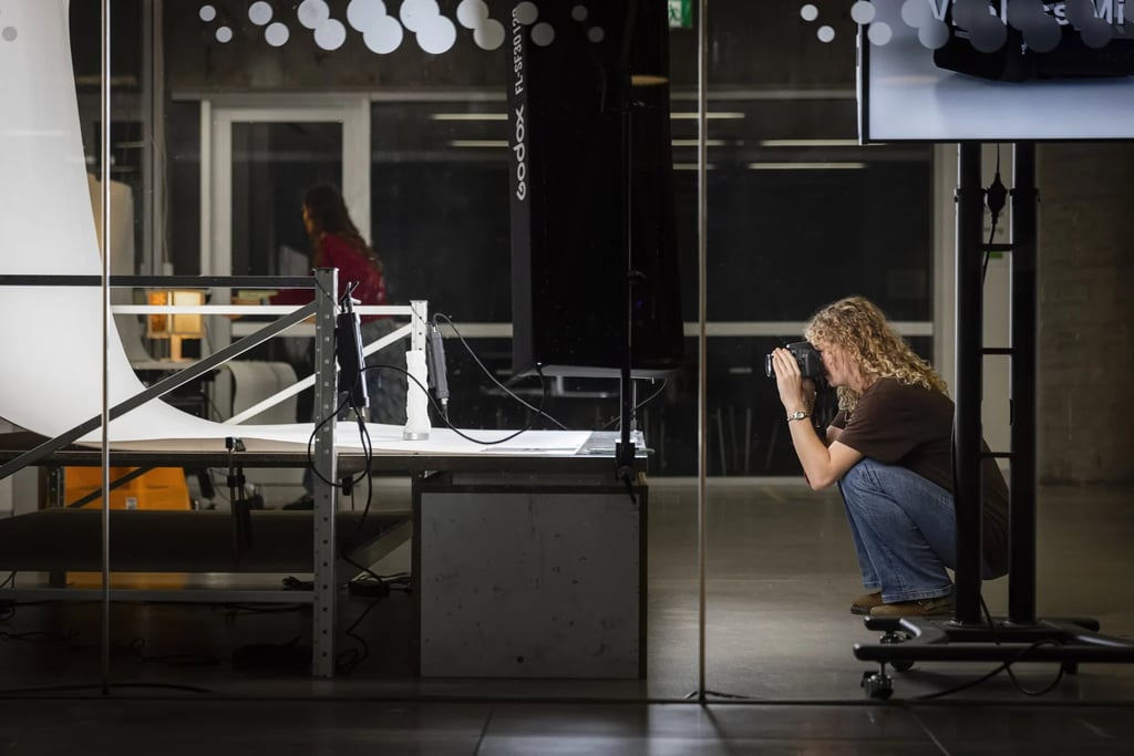 University student crouching to take a photo in a professional photography studio