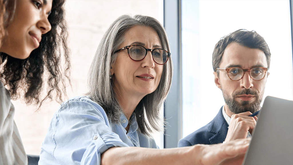 Mature businesswoman mentor with team members