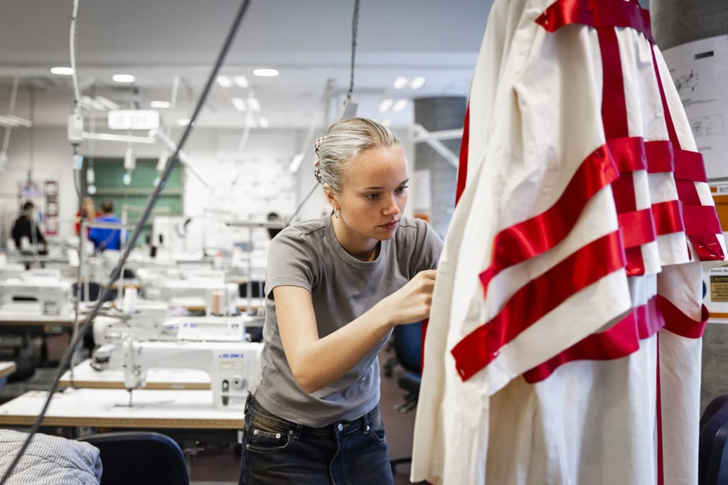 Student adjusting fabric on a mannequin