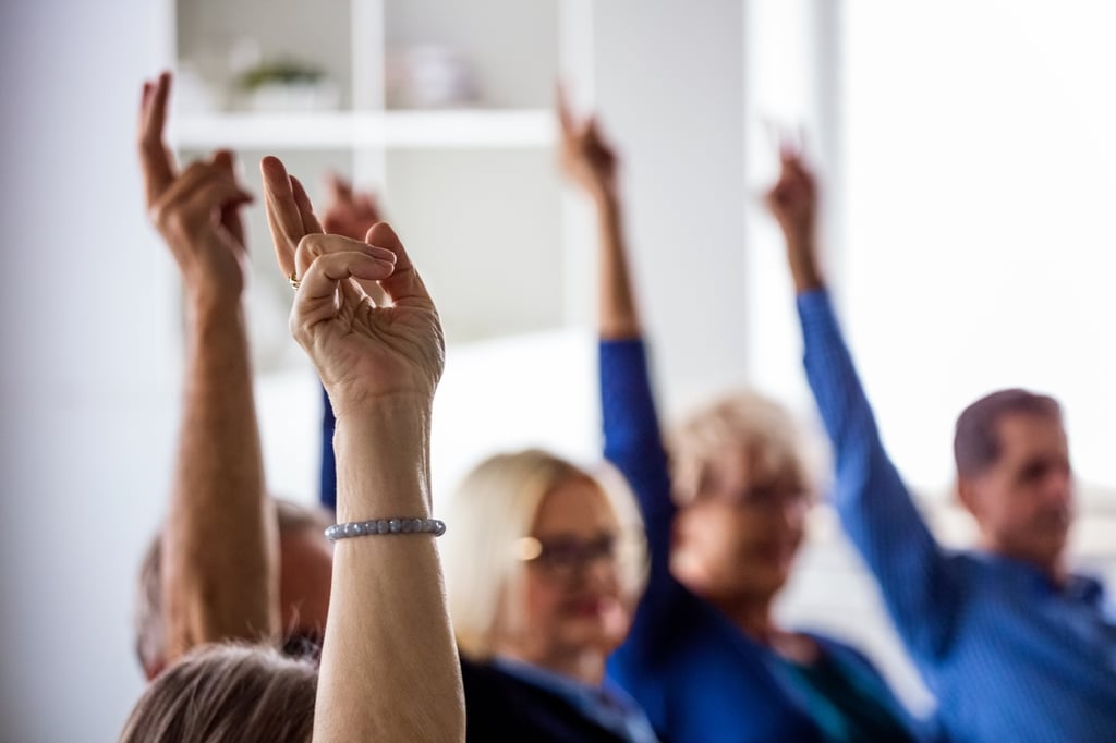 Room of people with their hands raised