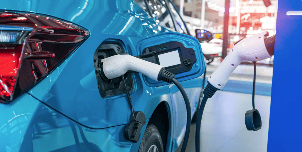 Charging cable plugged into the charging port of a blue electric vehicle.