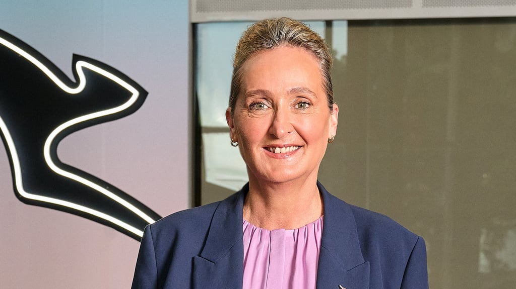 Vanessa Hudson standing in front of Qantas logo