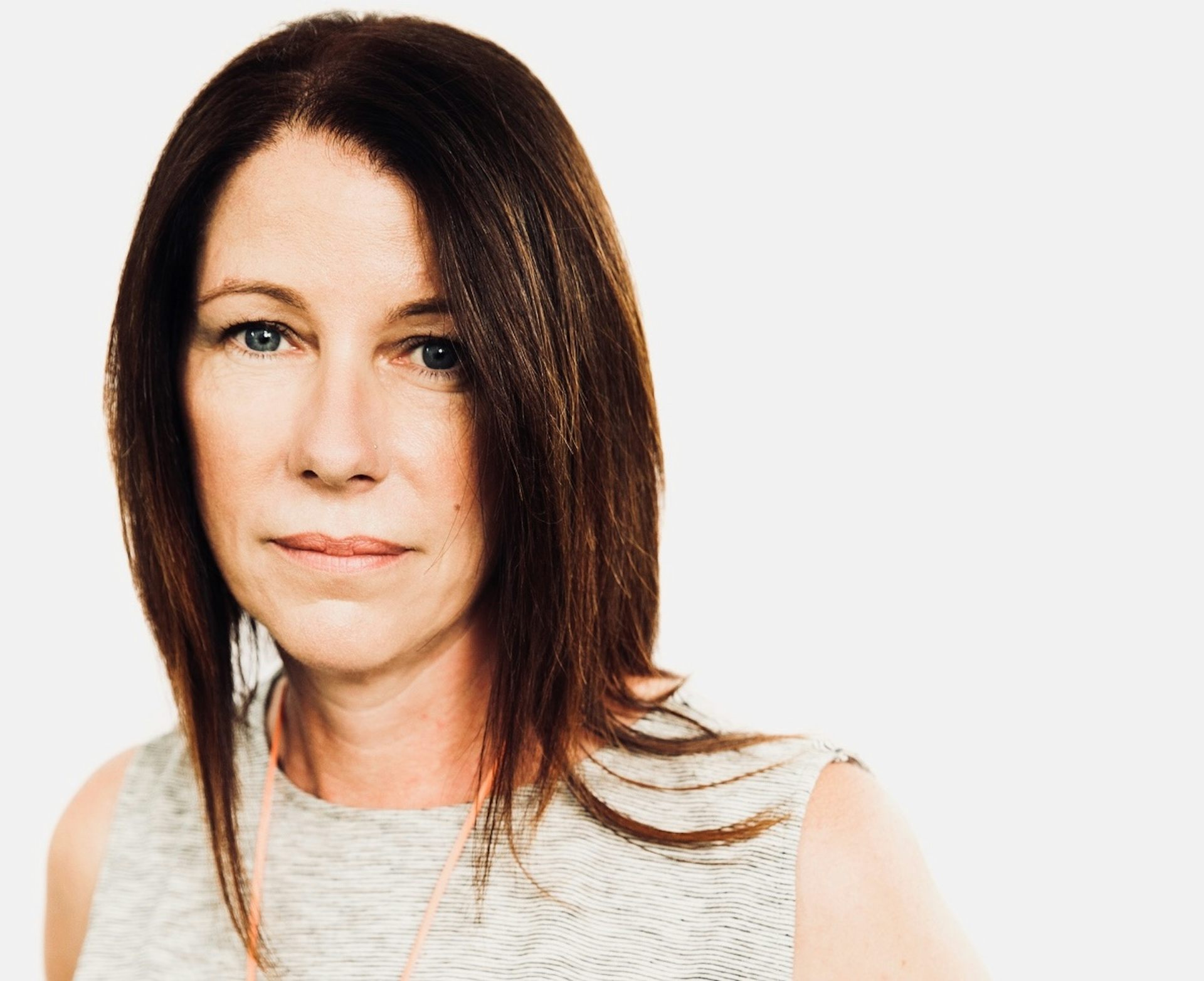 An attractive woman with a blunt, straight, choppy bob and a sleeveless t-shirt