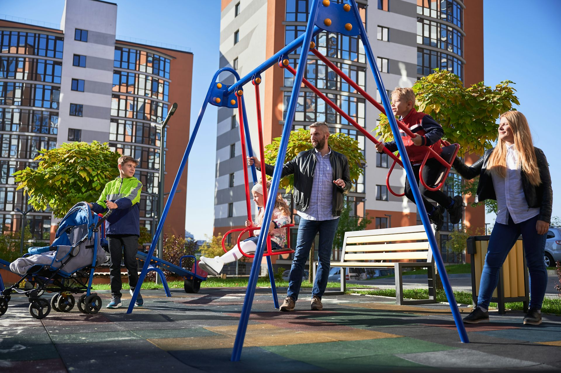 Families in a playground in front of high-rise apartments