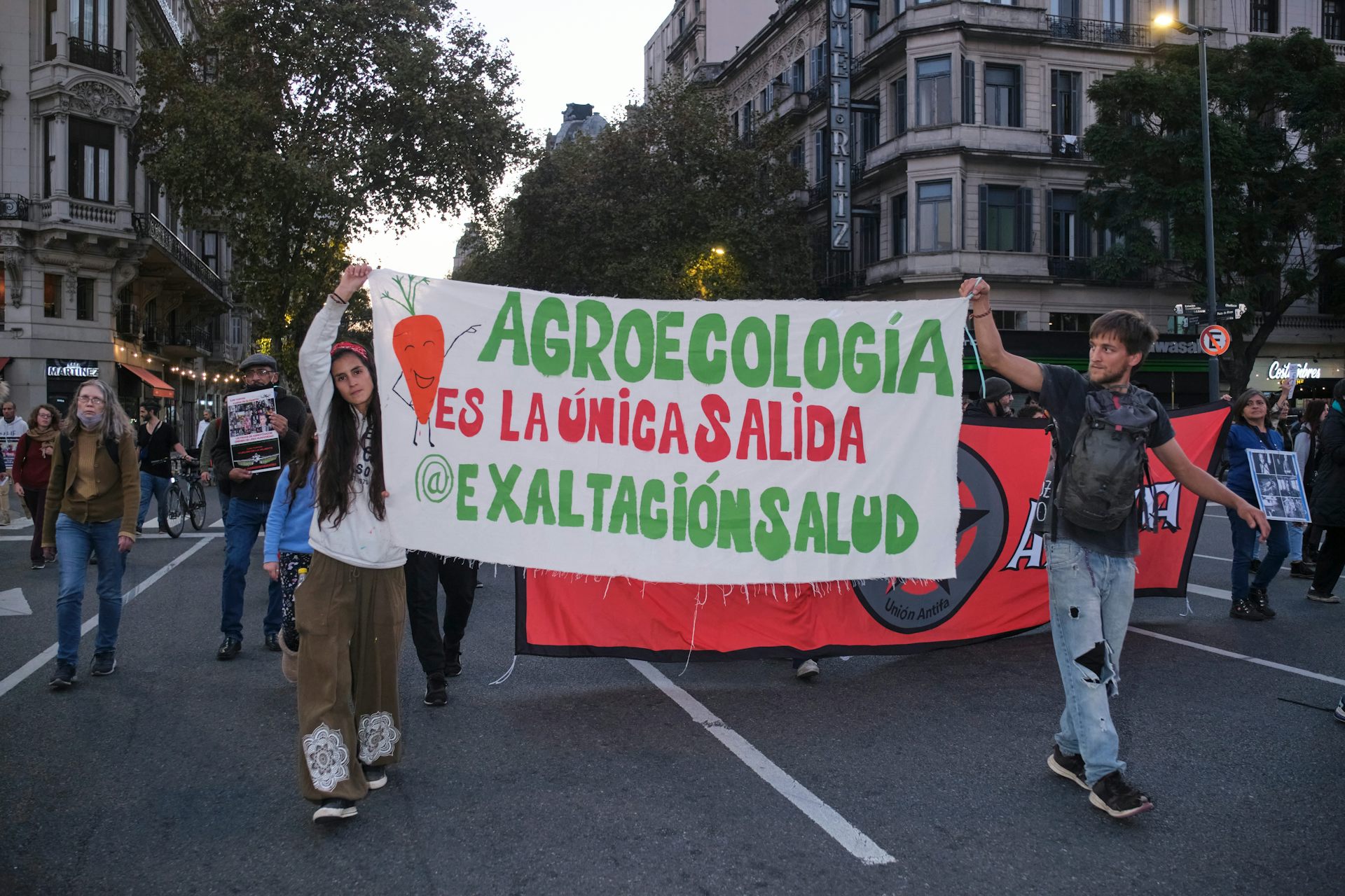 people march in protest holding sign in Spanish