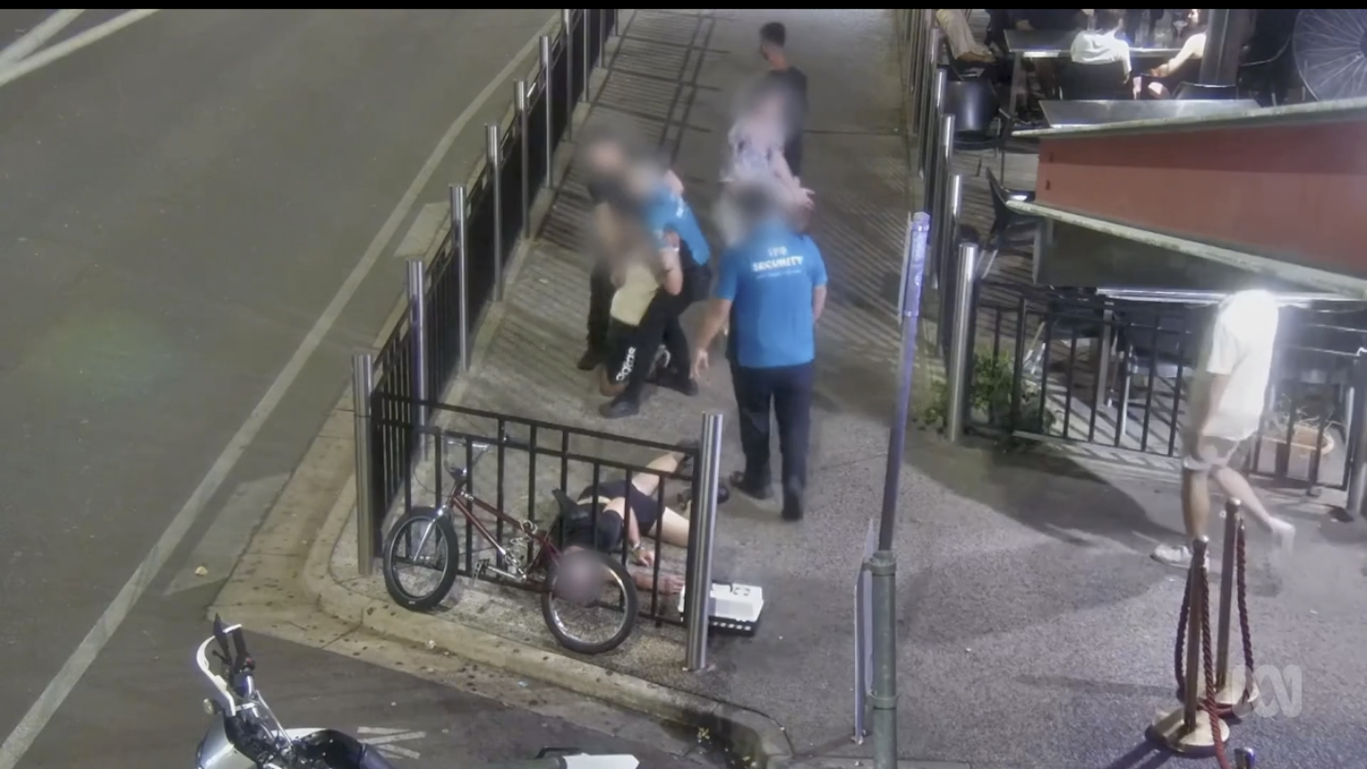 Security guards are fighting with patrons outside a nightclub.