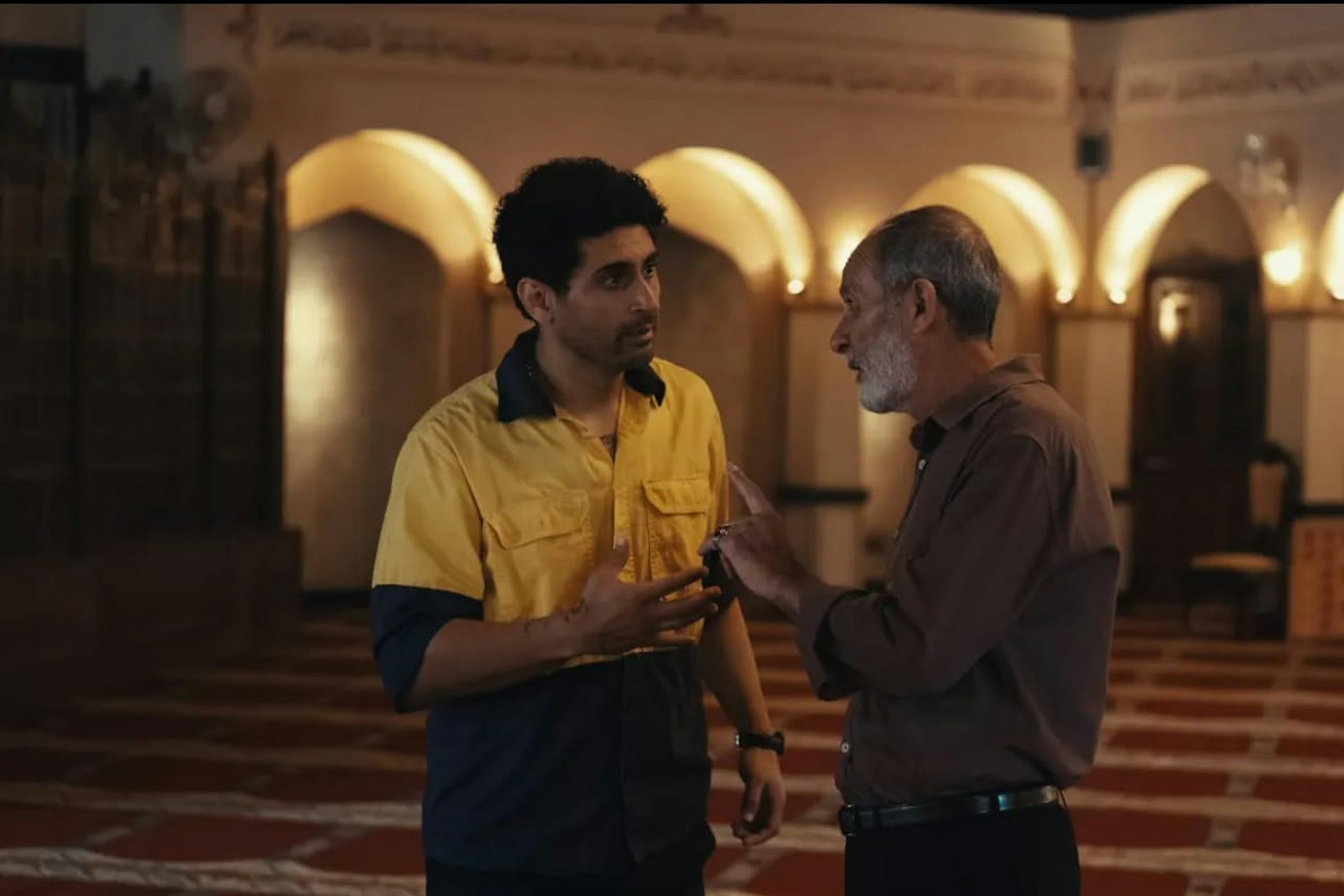 Two men, one young and one old, talking.