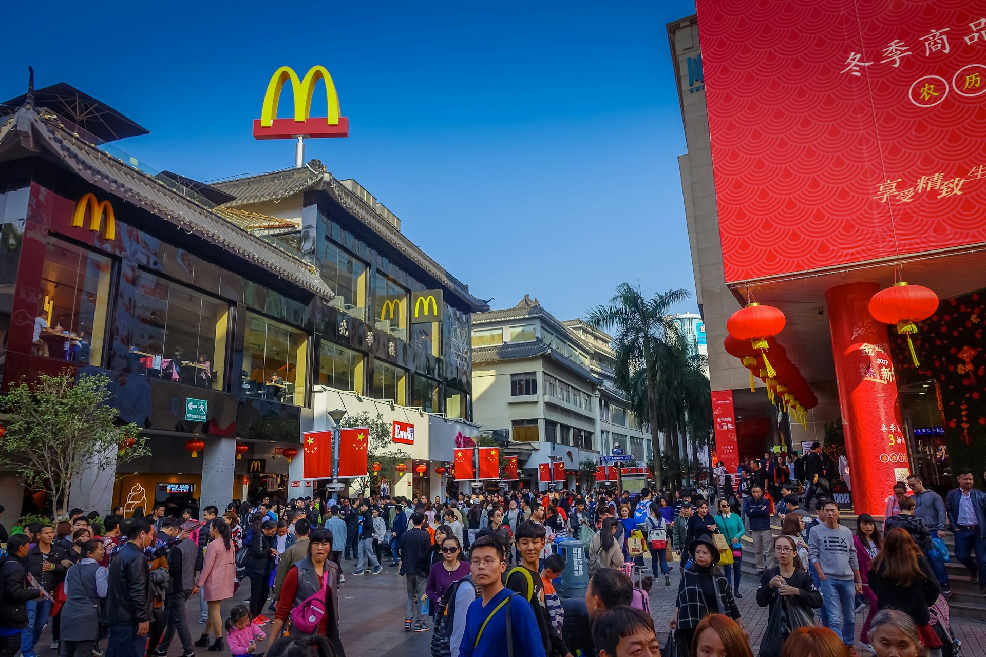 People walk past a McDonalds store in a busy Chinese street.