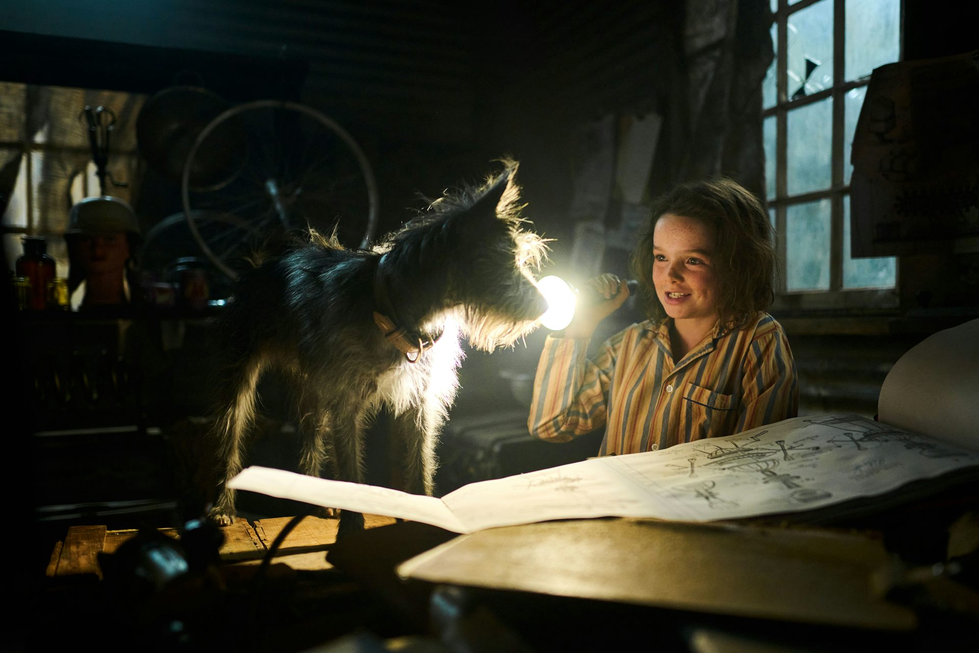 A dog, a girl with a flashlight, and inventor plans.