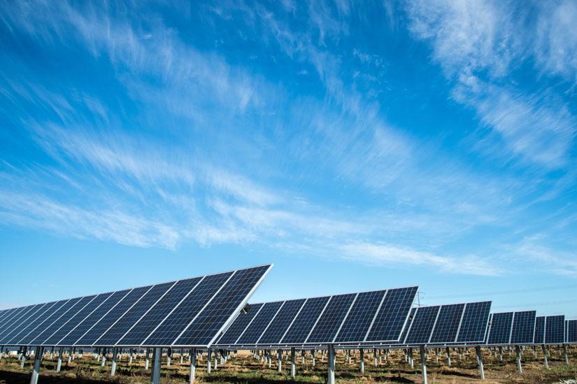 rows of solar panels against a blue sky