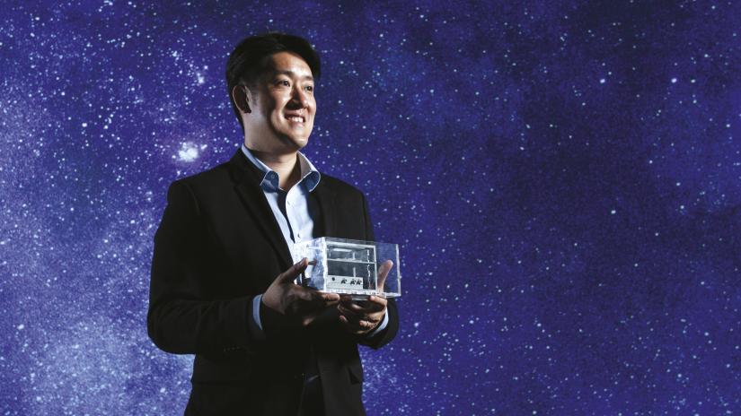 Joshua Chou holding the prototype microgravity device