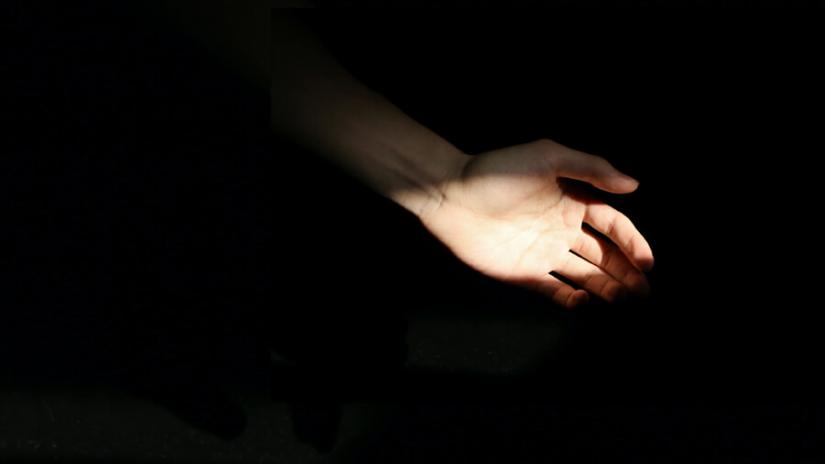 outstretched hand in the dark