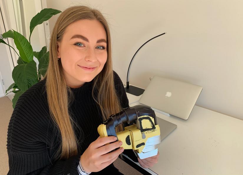 young woman holding crafted model of a hand mixer