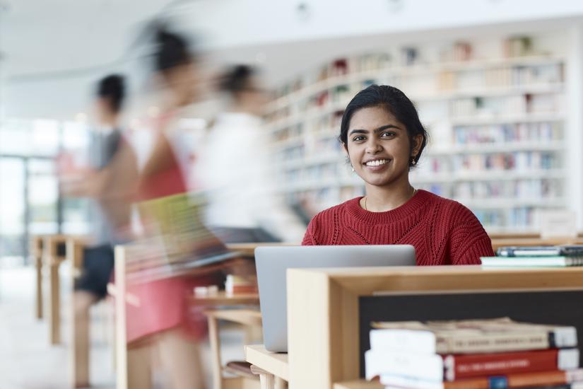 Female student wearing red jumper studying in UTS Library building two