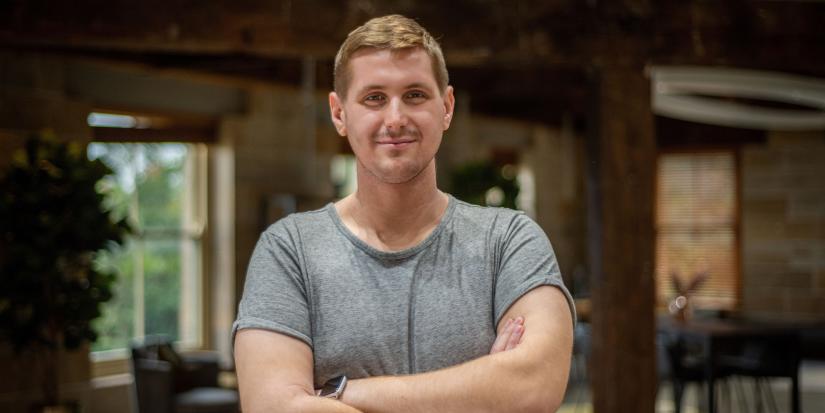 Data Science Engineering student Amir Tukic stands smiling, with arms folded