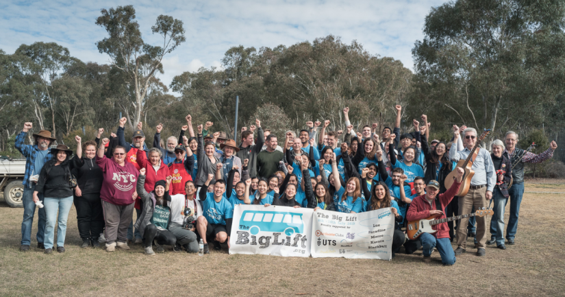 Group of students with their fists in the air on a volunteering trip with The Big Lift