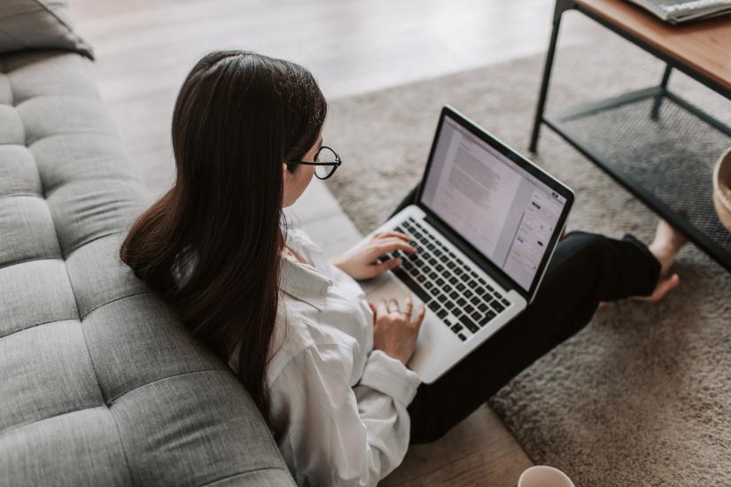 Woman sitting on the floor with a laptop on her knees