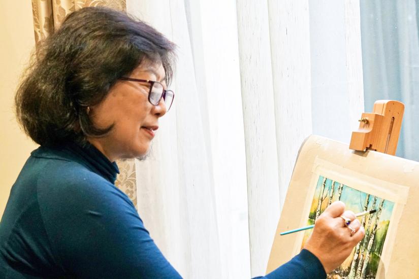 Jie Lu at her easel, painting