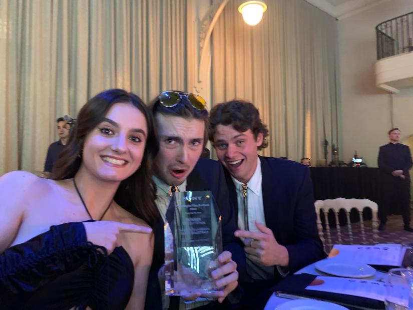 Tahlia, Kristo and Chris show their award to the camera.