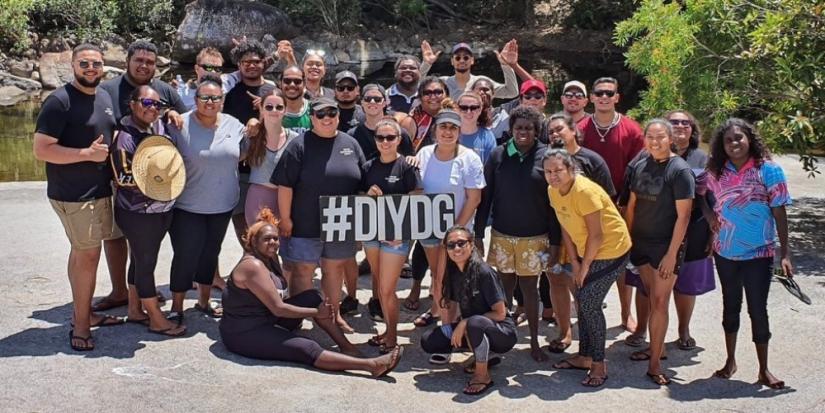 group of students standing in front of a water hole