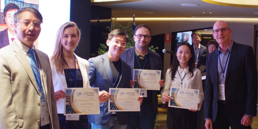 Best paper and honorable mention award winners receiving their certificates from two Professors