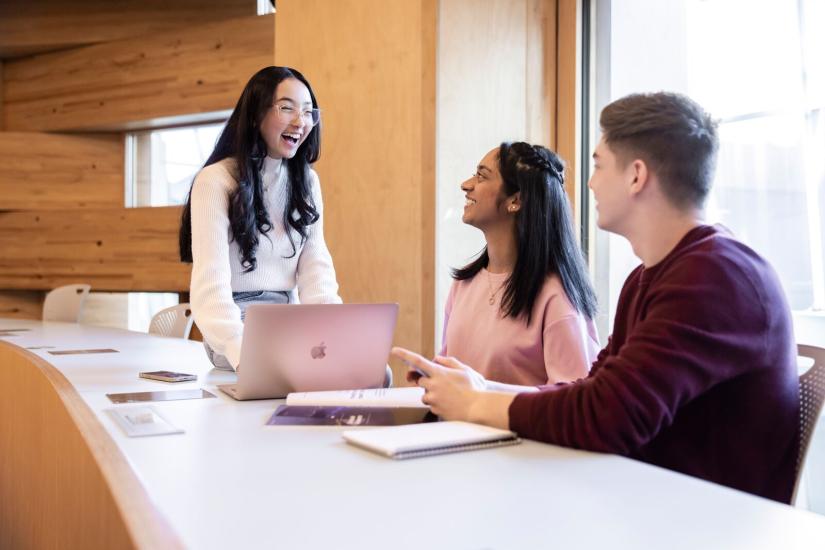 Three undergraduate students in the Business Oval Classroom