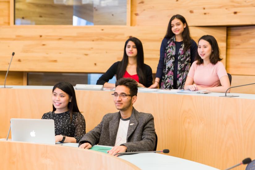Student smiling in the oval on level 2 in Business School